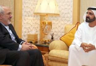 Iran’s Foreign Minister Mohammad Javad Zarif (L) smiles in his meeting with UAE Prime Minister Sheikh Mohammed Bin Rashid al-Maktoum in Dubai on April 15, 2014.