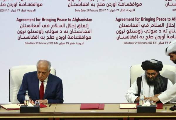 US Special Representative for Afghanistan Reconciliation Zalmay Khalilzad and Taliban co-founder Mullah Abdul Ghani Baradar sign a peace agreement during a ceremony in the Qatari capital Doha on February 29, 2020. - The United States signed a landmark deal with the Taliban, laying out a timetable for a full troop withdrawal from Afghanistan within 14 months as it seeks an exit from its longest-ever war. Pompeo called on the Taliban to honour its commitments to sever ties with jihadist groups as Washington signed a landmark deal with the Afghan insurgents.