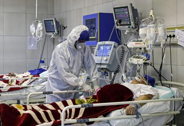 A medic treats a patient infected with coronavirus, at a hospital in Tehran.