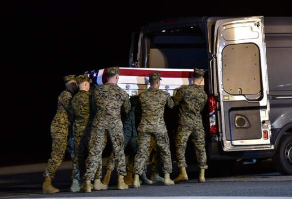 US military personnel carry a transfer case for a slain service member at Dover Air Force Base on March 11, 2020 in Dover, Delaware. (Photo by AFP)