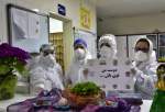 A group of nurses holding a paper with words:"Stay strong, my friend" as they stand behind Haft seen set, traditionally laid on the beginning of the Persian New Year. This year the New Year celebrations were all cancelled due to restrictions announced to battle coronavirus infection.