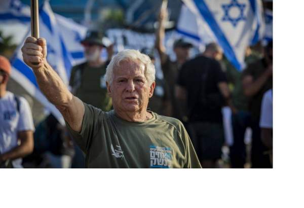 Reserve General Amiram Levin holds the Israeli flag during the demonstration outside the sea port of Haifa [Eyal Warshavsky/SOPA Images/LightRocket via Getty Images]