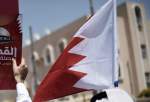 A Bahraini man holds up the national flag [MOHAMMED AL-SHAIKH/AFP via Getty Images]