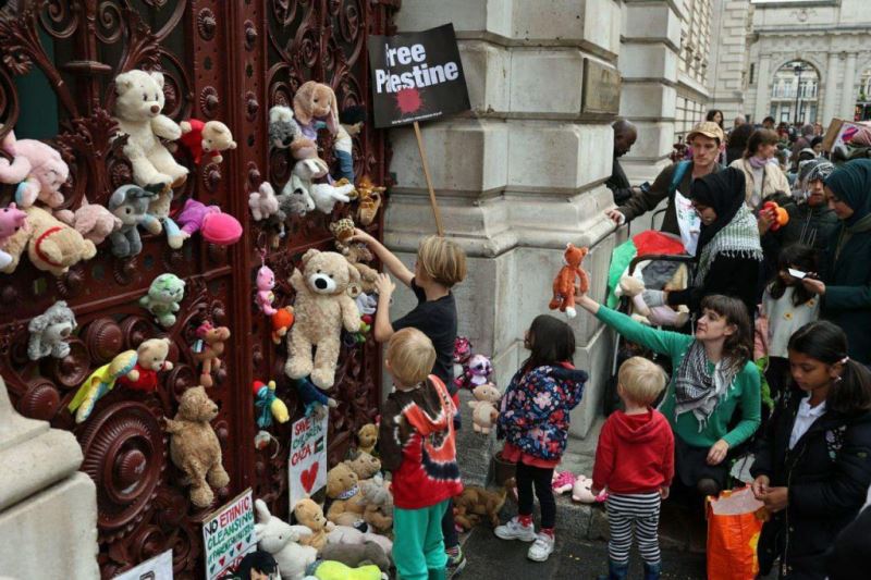 أطفال بريطانيون يعلقون دمى وكتابات مؤيدة لفلسطين على مدخل وزارة الخارجية البريطانية
