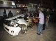 فلسطينيون يعاينون حطام السيارة التي استهدفتها الغارة الإسرائيلية على غزة أمس، رويترز