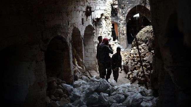 Syria foreign-backed militants pictured on April 16, 2013, standing amid sandbags in a damaged section of the Umayyad Mosque complex in Aleppo.