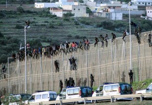 Hundreds of migrants storm Spanish enclave in North Africa, one dies