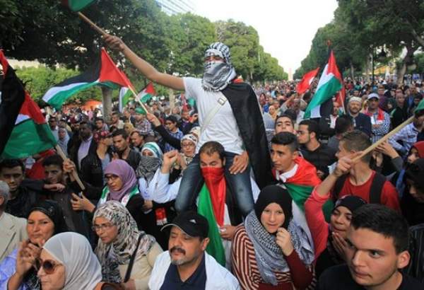 همبستگی تونسی ها با مردم فلسطین با تصاویر شهیدان سلیمانی و مغنیه