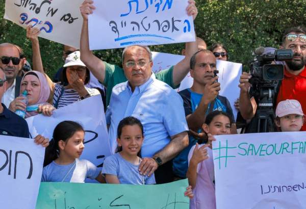 Ahmad Tibi and Ayman Odeh, members of the Israeli Knesset for the Joint List, attend a protest against the Israeli citizenship law in Jerusalem on 29 June 2021 (AFP)