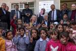 Children gesture as they pose for a photo with members of a European Union delegation and the Palestinian Education Minister Marwan Awartani at a school facing demolition by Israel in Khashm el-Karm, south of the village of Yatta in the occupied West Bank on January 25, 2023 [HAZEM BADER/AFP via Getty Images]