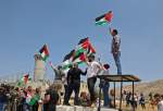 متظاهرون فلسطينيون يلوحون بالعلم الفلسطيني في مدينة طوباس، شمالي الضفة الغربية