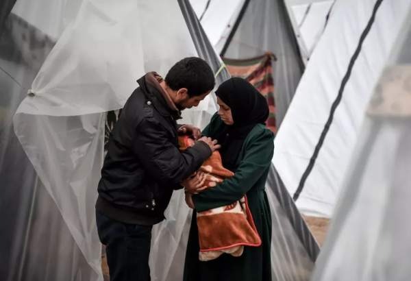 A Gazan mother, Sabreen al-Azami, who was displaced from Beit Lahia city when she was 7 months pregnant due to Israeli attacks and took refuge in a tent, is seen holding her daughter Sukkar on her arms in Rafah, Gaza on December 23, 2023. The mother and her baby born a week ago live in the tent under difficult conditions with health problems. [Abed Zagout/Anadolu via Getty Images]
